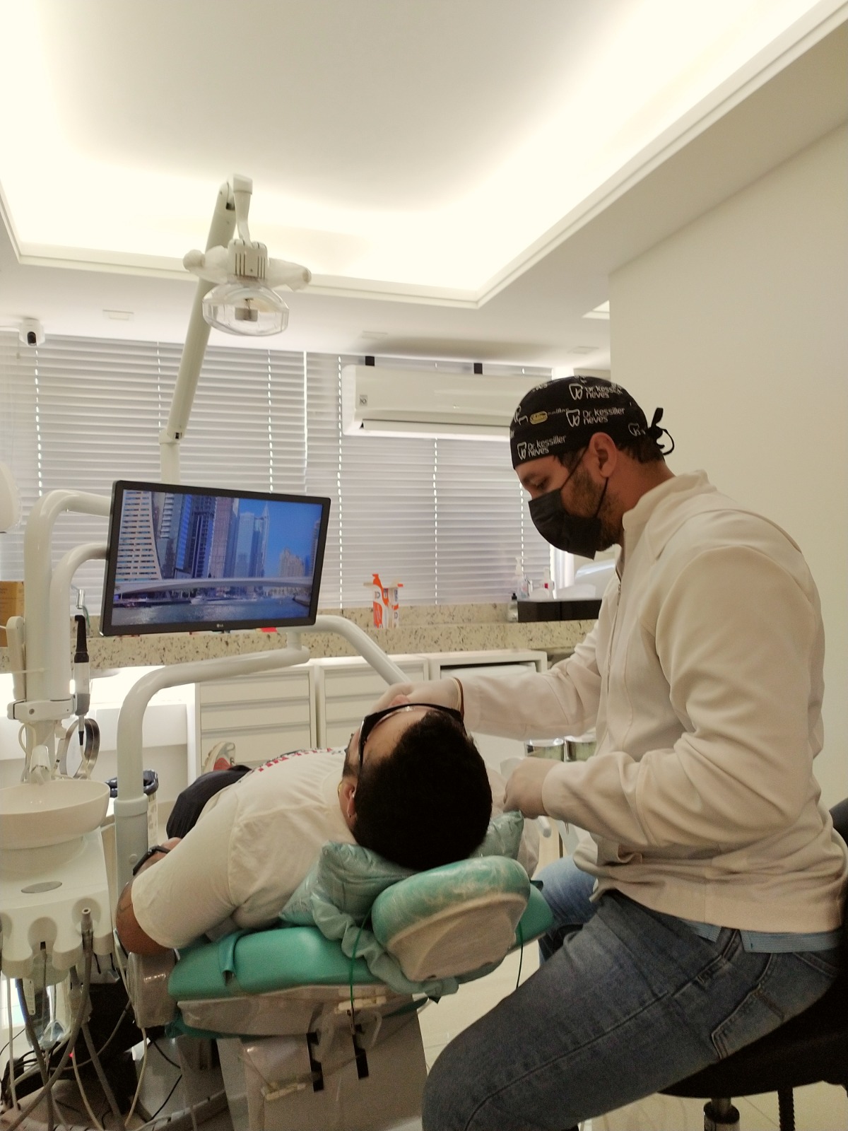 Dr. Kessiller Neves atendendo um paciente na cadeira odontológica do consultório em Governador Valadares